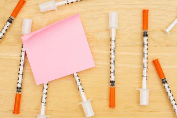 ワクチンまたはCovidメッセージのための付箋が付いた机の上の使い捨てワクチン針 — ストック写真