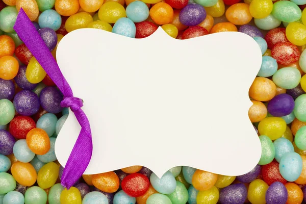 あなたのイースターやキャンディーメッセージのためのカラフルなジェリービーンズキャンディーの上に空白のギフトタグ — ストック写真