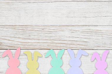 Bayram veya Paskalya mesajı için tahıllı ahşap arka planda Paskalya Tavşanları