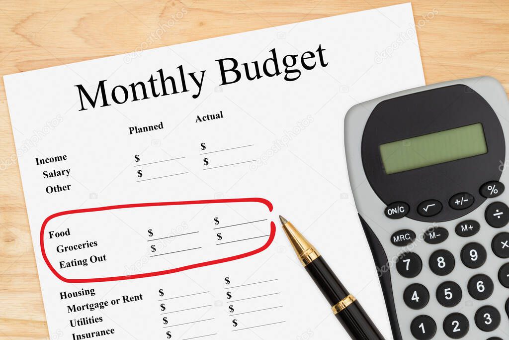 Cost of your monthly budget with cost for food focused with a calculator and pen on a wood desk