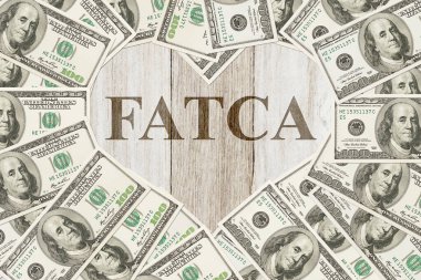 Amerikan Dış Vergi Uygunluğu Yasası 'na uygun olarak kalbi kırık bir kalp şeklinde 100 dolarlık banknot ve FATCA metni.