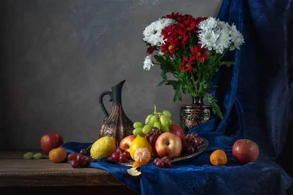 Still life with flowers, fruit and a jug of wine. — Stock Photo, Image