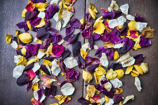 Сухие лепестки роз на деревянном фоне — стоковое фото