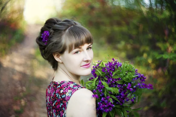 Schöne junge Frau mit Blumen — Stockfoto