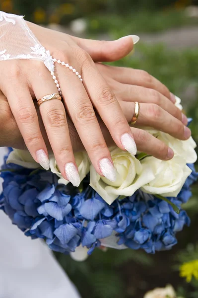 Bouquet and hands with rings — Stock Photo, Image