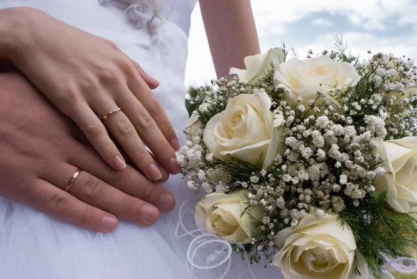 Bouquet and hands with rings — Stock Photo, Image