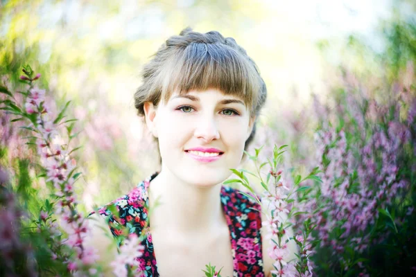 Schöne junge Frau mit Blumen — Stockfoto