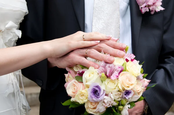 Bouquet and hands with rings — Stock Photo, Image