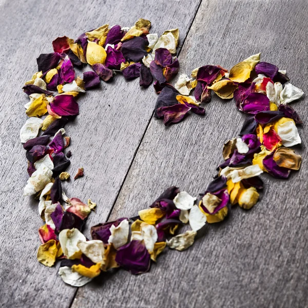 Hintergrund mit einem Herzen aus Rosenblättern zum Valentinstag — Stockfoto