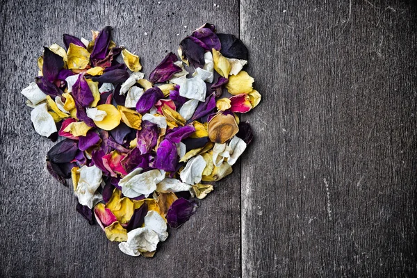 Hintergrund mit einem Herzen aus Rosenblättern zum Valentinstag — Stockfoto