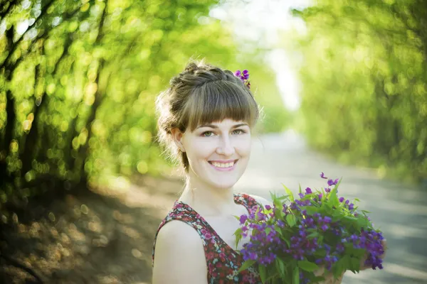 Beautiful young woman with flowers — Stock Photo, Image