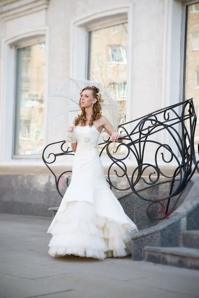 Bella sposa in abito bianco con ombrello — Foto Stock