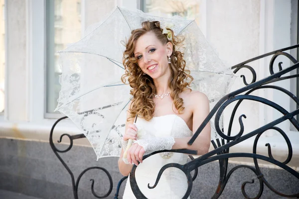 Bella sposa in abito bianco con ombrello — Foto Stock