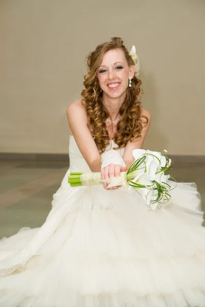Belle mariée dans une robe blanche avec un bouquet de lys calla — Photo