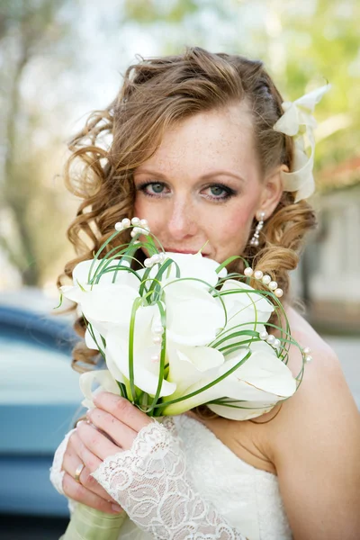 オランダカイウユリの花束と白いドレスを着た美しい花嫁 — ストック写真