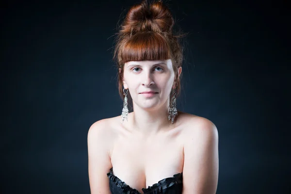 Portrait of a young woman in studio on a gray background — Stock Photo, Image