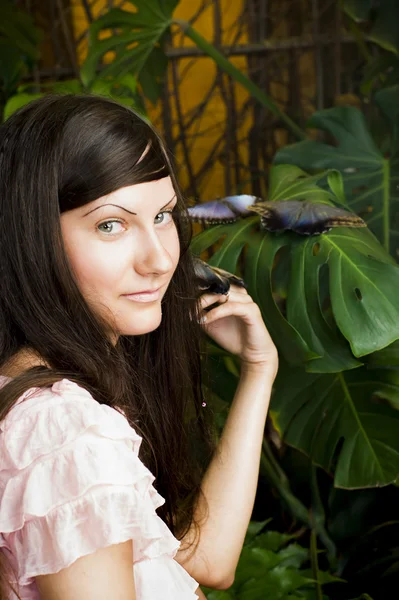 Portrait of beautiful girl with butterfly in a greenhouse — Stock Photo, Image