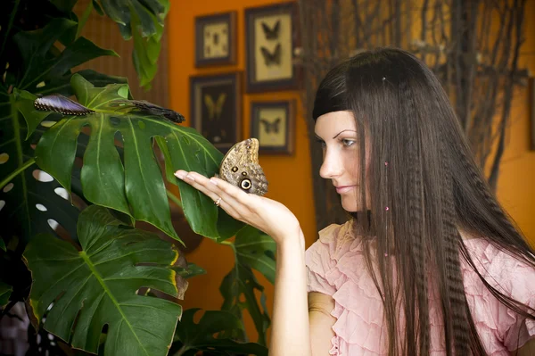 Portrait de belle fille avec papillon dans une serre — Photo