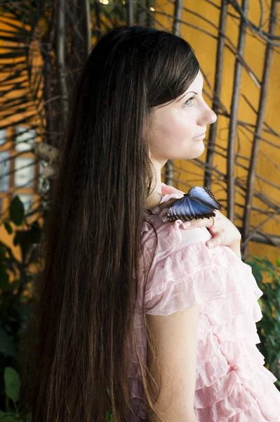 Ritratto di bella ragazza con farfalla in serra — Foto Stock