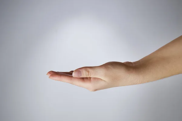 Vrouwelijke hand op een grijze achtergrond — Stockfoto