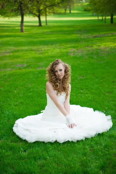 Schöne Braut im weißen Kleid auf grünem Gras im Sommer — Stockfoto