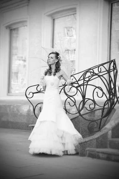 Beautiful bride in white dress with umbrella — Stock Photo, Image