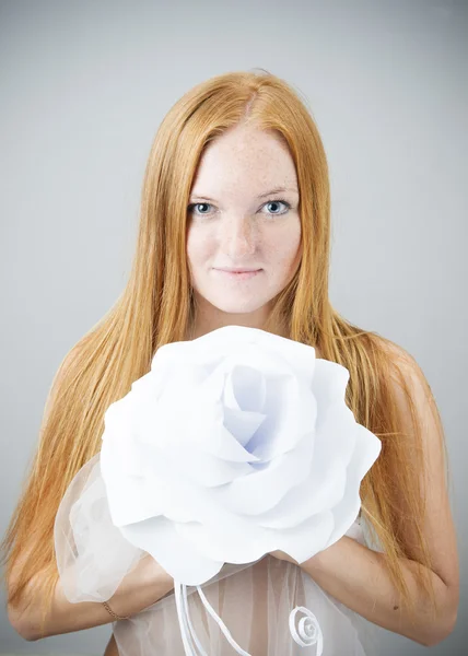 Портрет рыжеволосой женщины с цветком бумаги — стоковое фото