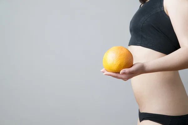 Женское тело с красным грейпфрутом — стоковое фото