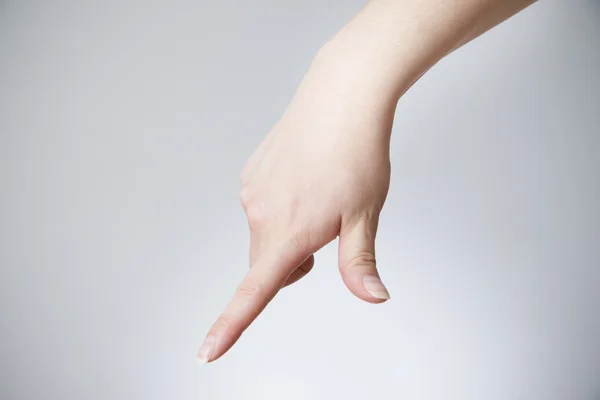 Vrouwelijke hand op een grijze achtergrond — Stockfoto