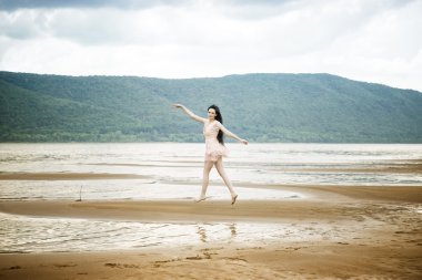 kumlu bir plaj üzerinde güzel bir genç kadın