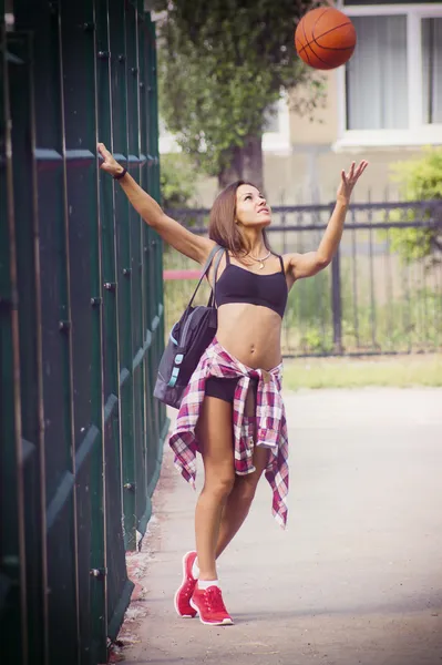 Beautiful young woman playing basketball outdoors — Stock Photo, Image