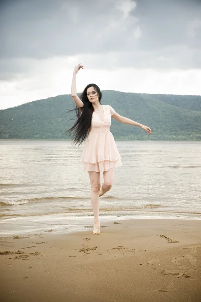 Beautiful young woman on a sandy beach — Stock Photo, Image