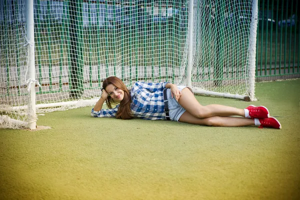 Schöne junge Frau auf dem Fußballplatz — Stockfoto