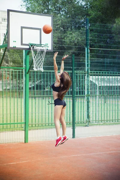 Beautiful young woman playing basketball outdoors — Stock Photo, Image