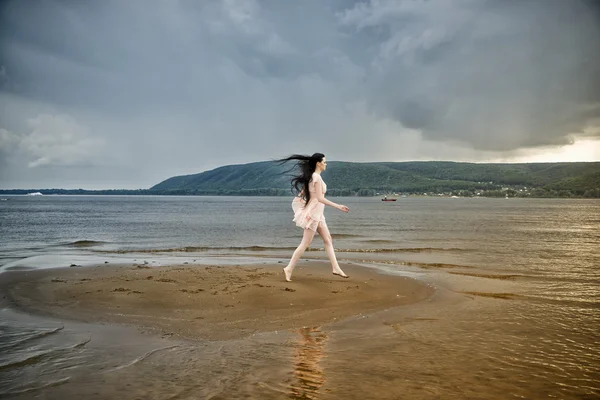 Beautiful young woman on a sandy beach — Stock Photo, Image