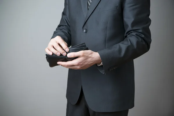 Businessman with empty purse in hands — Stock Photo, Image