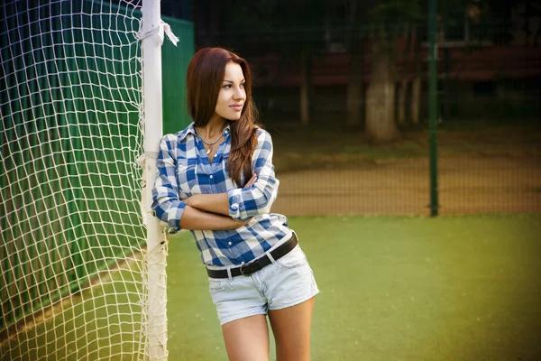 Mooie jonge vrouw op het voetbalveld — Stockfoto