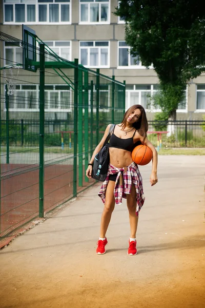 Vacker ung kvinna spela basket utomhus — Stockfoto