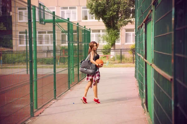 Όμορφη νεαρή γυναίκα που παίζει μπάσκετ σε εξωτερικούς χώρους — Φωτογραφία Αρχείου