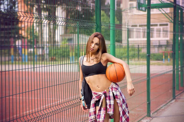 Belle jeune femme jouant au basket en plein air — Photo