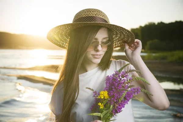 Ritratto di una bella donna in cappello sullo sfondo di un tramonto — Foto Stock