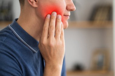 Diş ağrısı olan bir adam, yirmilik dişli periodontal bir hastalık, kırmızı ile işaretlenmiş acı verici bir bölge.