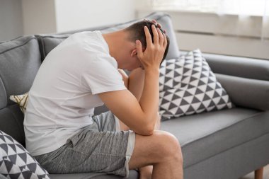 Baş ağrısı ve migren, evde baş ağrısı olan bir adam, sağlık sorunları konsepti.