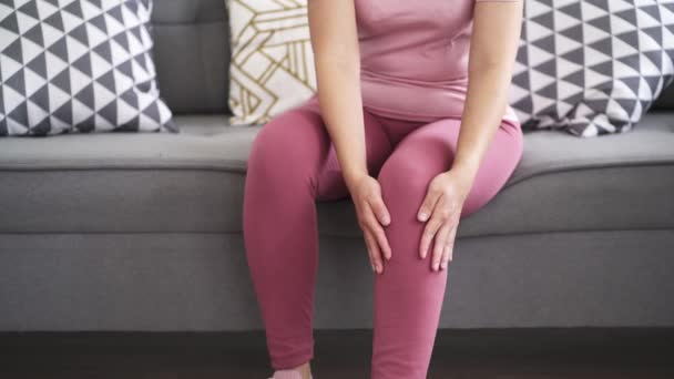 膝の痛み 痛みに苦しんでいる女性と自宅で自己マッサージを行う 自己なだめるようなマッサージ — ストック動画