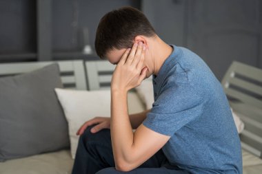 Man with earache, ear pain at home, health problems concept