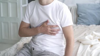 Kalp krizi, göğüs ağrısı olan bir adam evde acı çekiyor, sağlık sorunları kavramı.