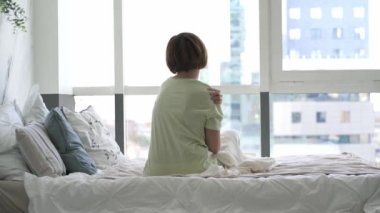 Yatak odasında kendine masaj yapan bir kadın, kendini rahatlatan bir masaj.