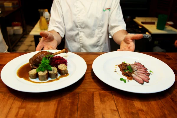 Cook holding two goose in the kitchen — Stock Photo, Image