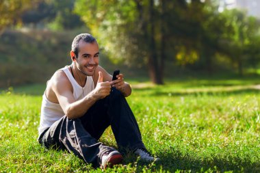 park ve LIS çimlere oturup rahat, genç bir adam portresi