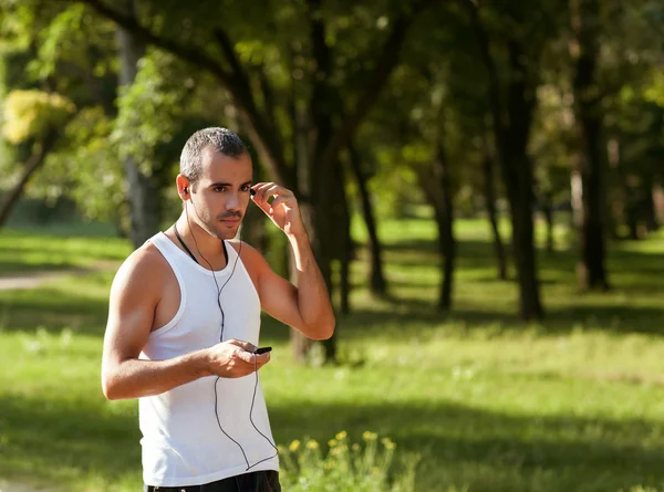 Healthy Looking Young Man Jogging in the Woods Under Morning Sun — Stockfoto